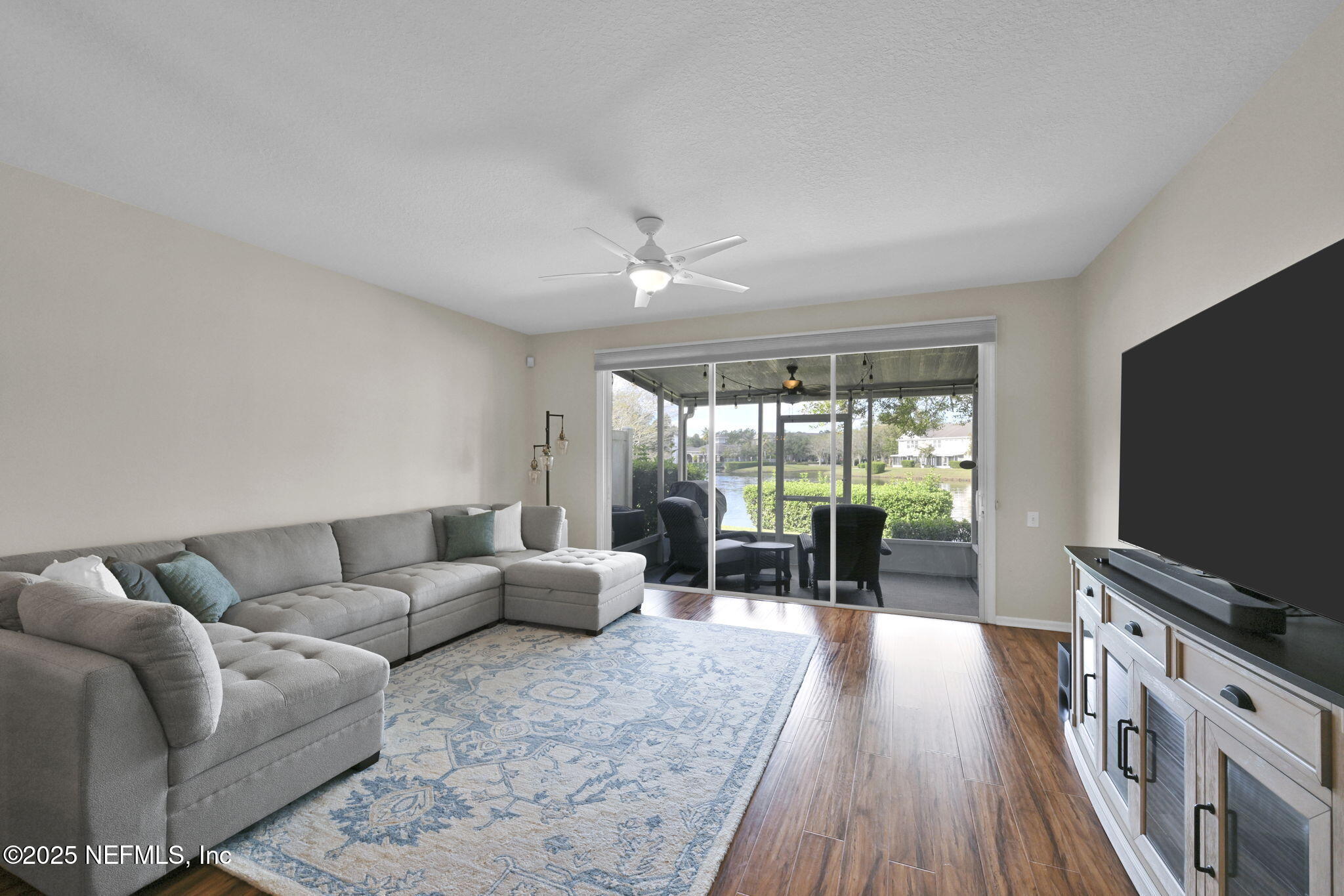 7990 Baymeadows Road East, Unit 2302 Jacksonville, FL 32256 - Photo 19 of 66 a living room with furniture a flat screen tv and floor to ceiling window