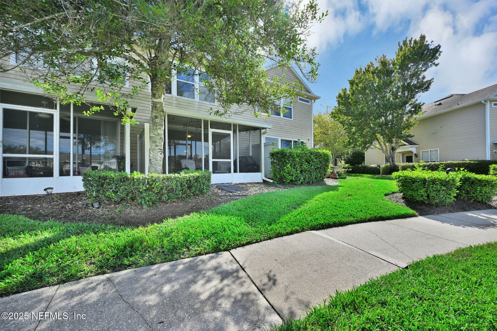 7990 Baymeadows Road East, Unit 2302 Jacksonville, FL 32256 - Photo 40 of 66 a view of a brick house with a yard and large tree