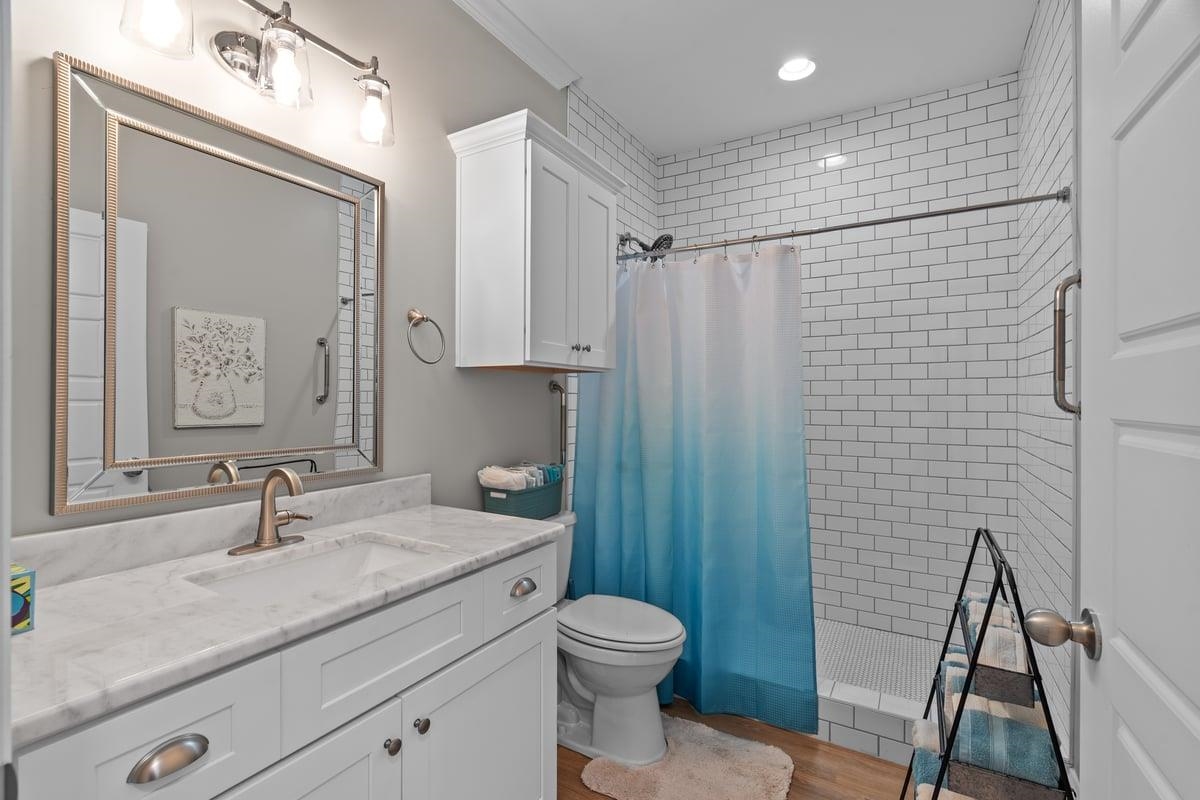 678 Morris Road Covington, TN 38019 - Photo 36 of 40 Bathroom featuring a tile shower, vanity, light wood finished floors, and recessed lighting