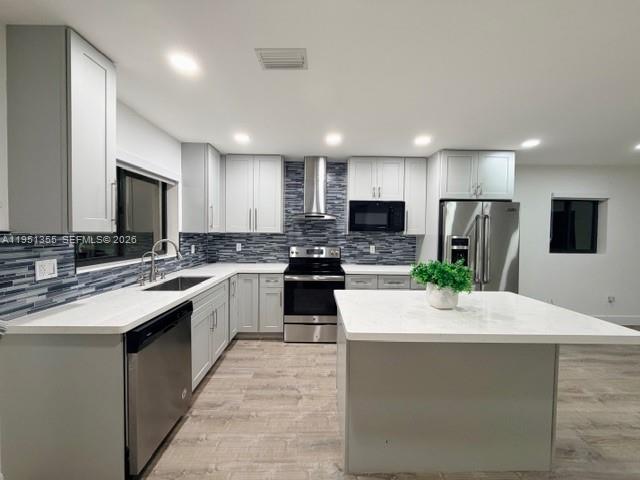 14720 Southwest 107th Terrace Miami, FL 33196 - Photo 3 of 18 a large kitchen with kitchen island a sink stainless steel appliances and cabinets