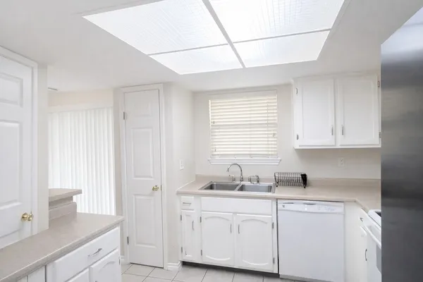 a kitchen with granite countertop white cabinets and white appliances