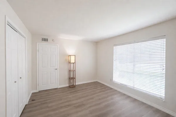 an empty room with wooden floor and windows