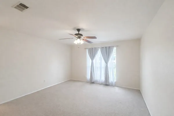 a view of an empty room with a chandelier fan