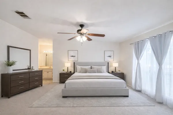 a bedroom with a large bed and a chandelier