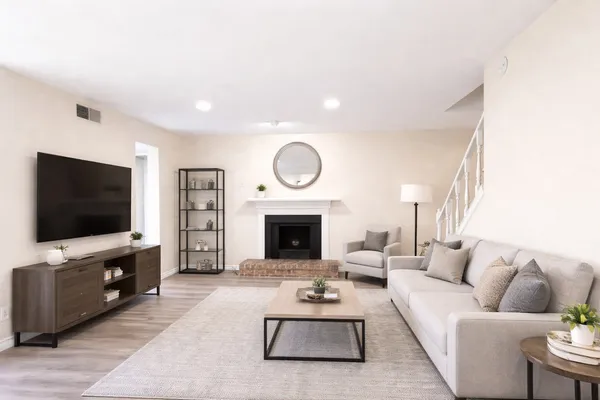 a living room with furniture a fireplace and a flat screen tv