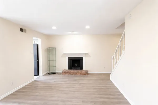 a view of a livingroom with wooden floor and a fireplace