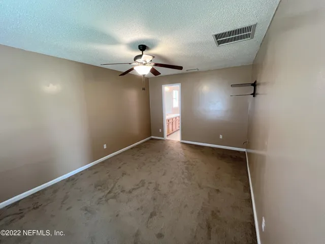 an empty room with a ceiling fan and a window