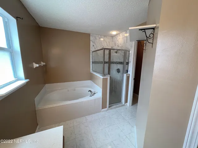 a bathroom with a tub sink and mirror