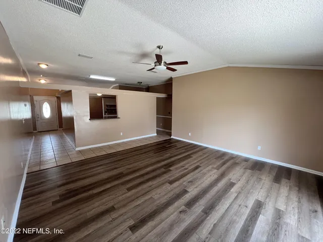 a view of an empty room and wooden floor