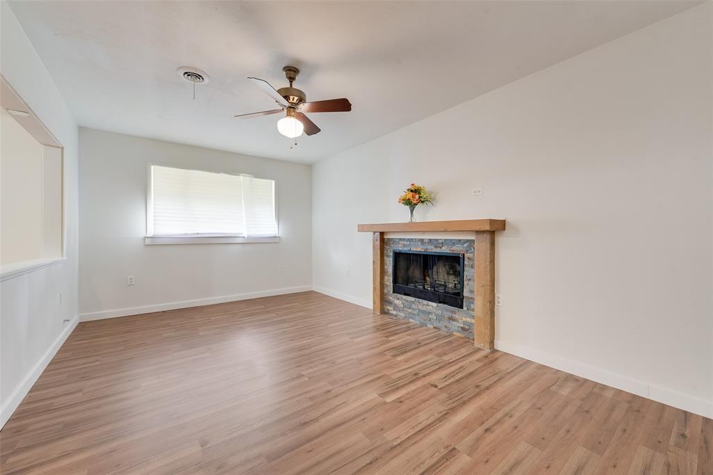 1104 Trinity View Street Irving, TX 75060 - Photo 11 of 34 an empty room with wooden floor fireplace and windows