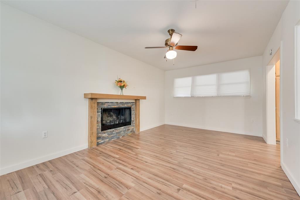 1104 Trinity View Street Irving, TX 75060 - Photo 13 of 34 a view of an empty room with wooden floor fireplace and a window