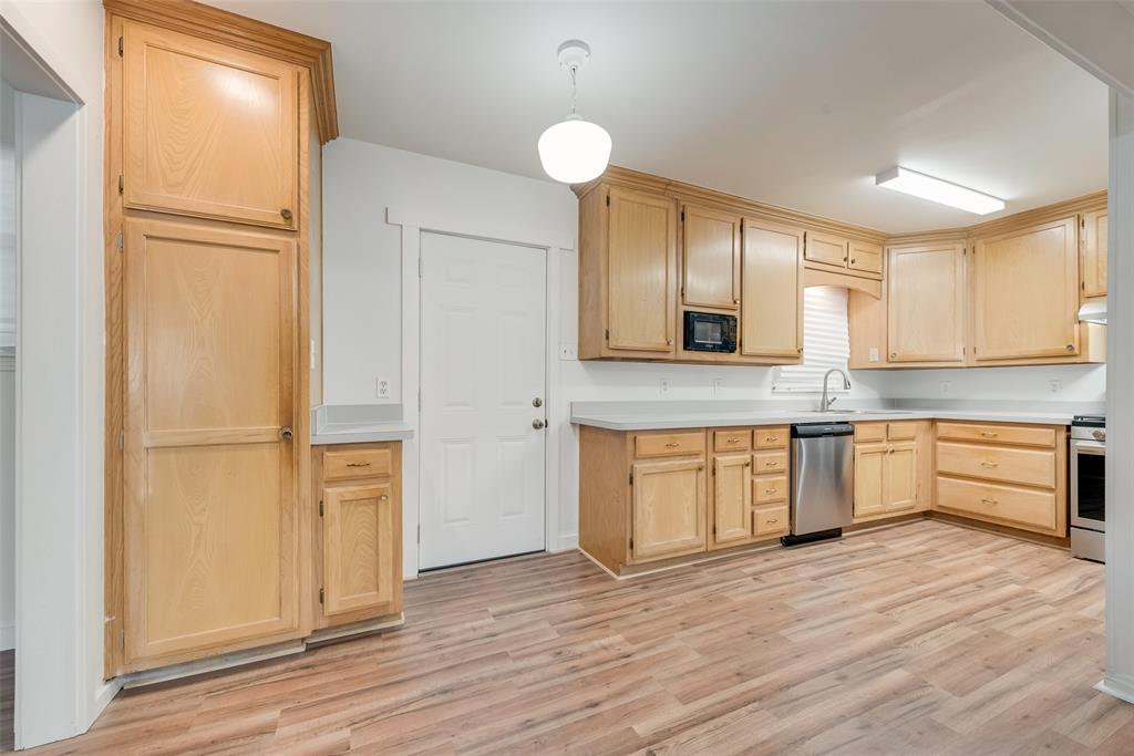 1104 Trinity View Street Irving, TX 75060 - Photo 15 of 34 a kitchen with granite countertop a refrigerator and cabinets