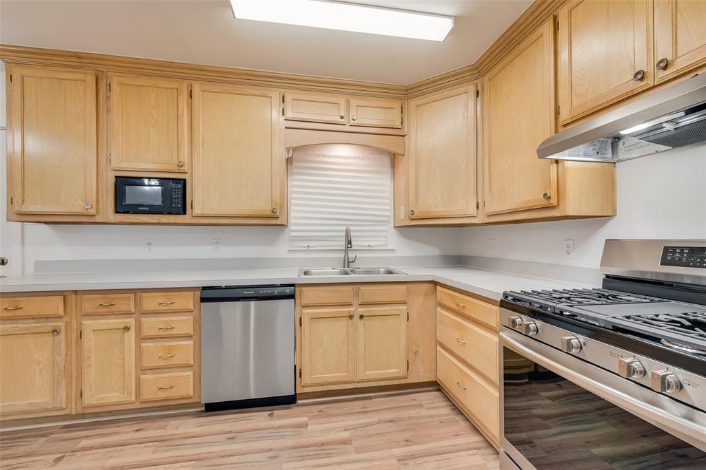1104 Trinity View Street Irving, TX 75060 - Photo 17 of 34 a kitchen with granite countertop wooden cabinets stainless steel appliances and a sink