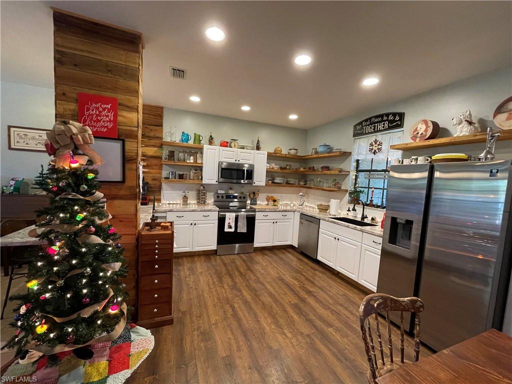 14908 Summit Pl Circle, Unit 26 Naples, FL 34119 - Photo 4 of 32 a kitchen that has a lot of white cabinets and stainless steel appliances