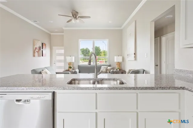 a kitchen with granite countertop a sink a counter top space and cabinets