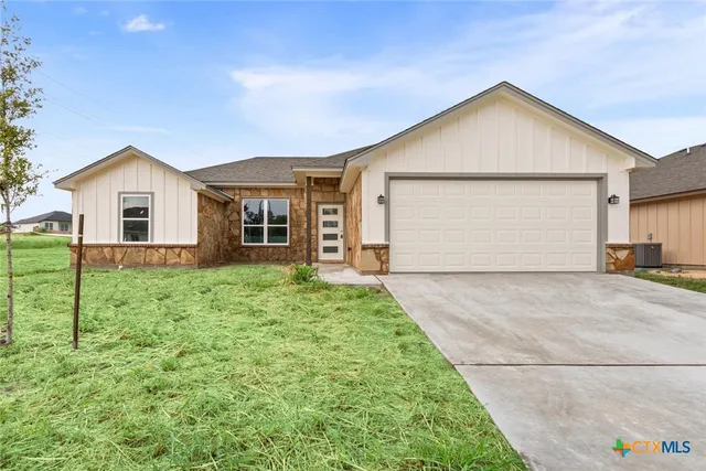 a view of a house with a yard and garage