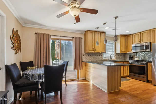 a kitchen with granite countertop a table chairs microwave and cabinets