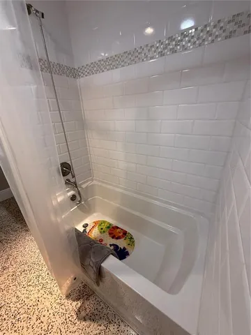 a bathroom with a tub a sink and a shower