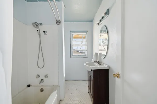 a bathroom with a granite countertop sink a window and shower