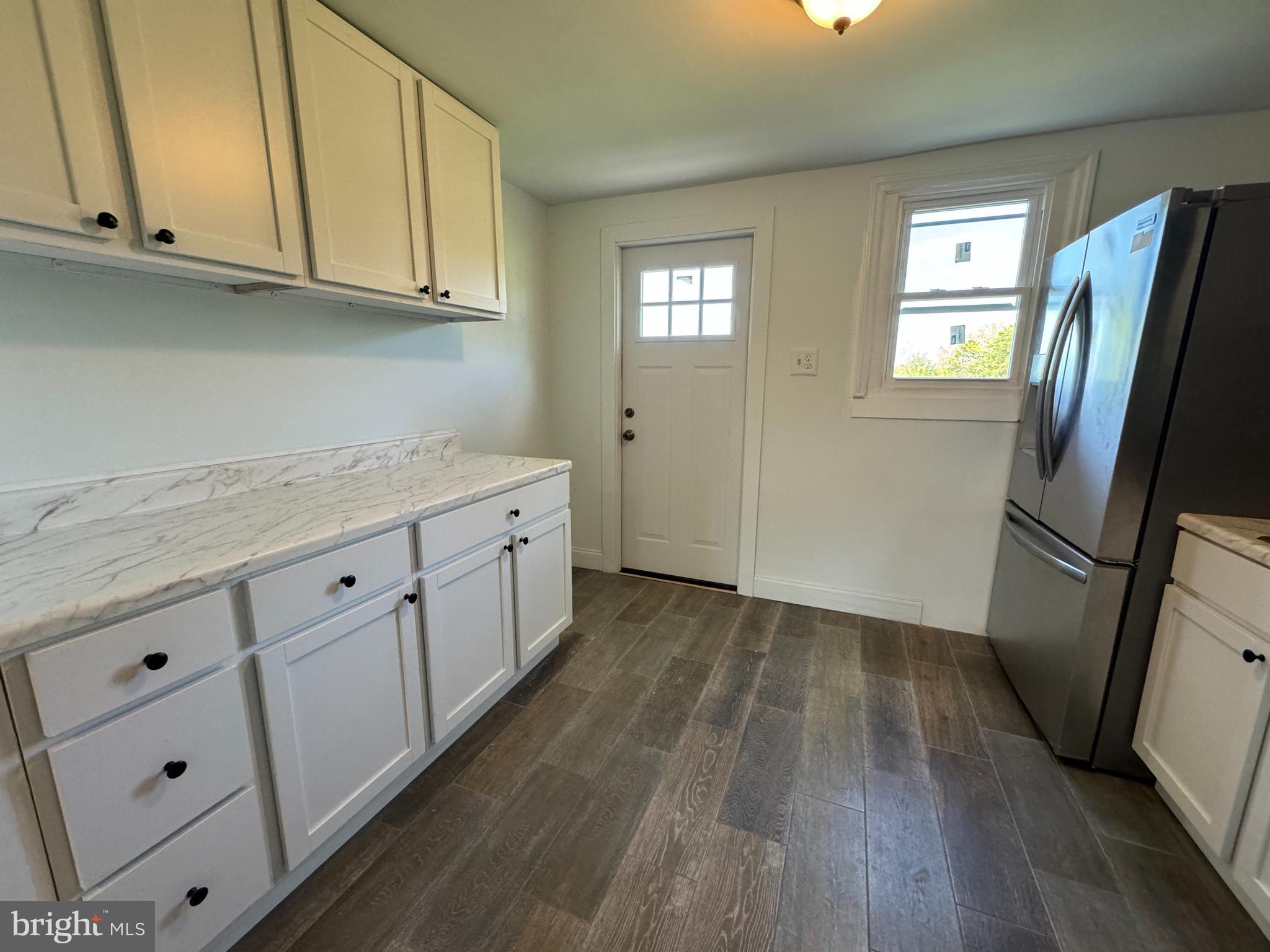3754 Baltimore Pike, Unit 2 Littlestown, PA 17340 - Photo 7 of 24 a kitchen with granite countertop a refrigerator a sink and white cabinets