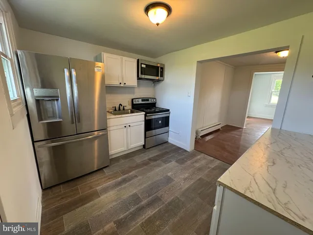 a kitchen with stainless steel appliances granite countertop a refrigerator a stove and a sink