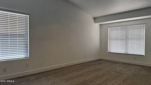 a view of an empty room with chandelier fan