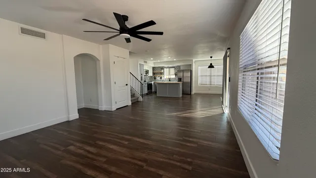 a view of a kitchen with fridge and wooden floor