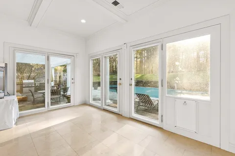 a view of an empty room with glass door and a window