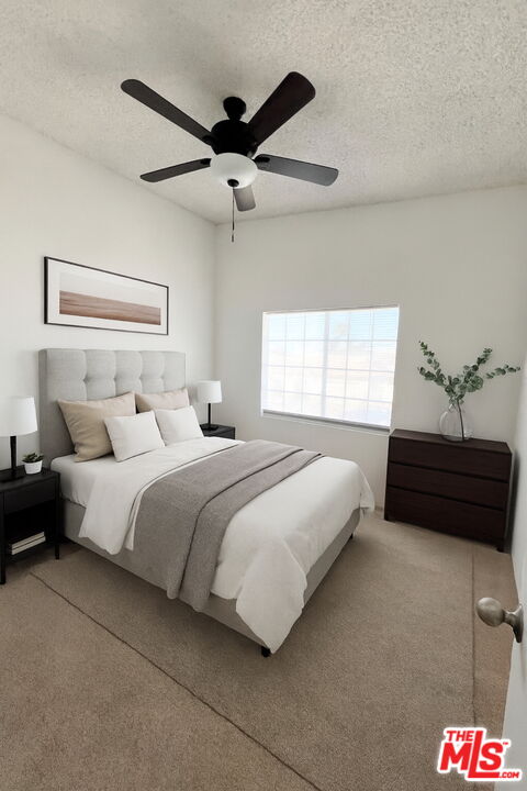 a bedroom with a bed and a ceiling fan