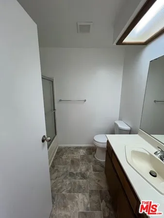 a bathroom with a sink and mirror with toilet