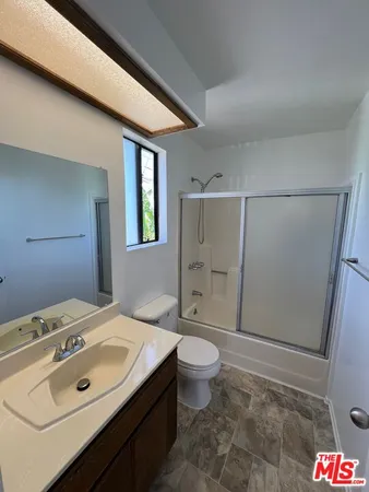a bathroom with a sink toilet double vanity and shower