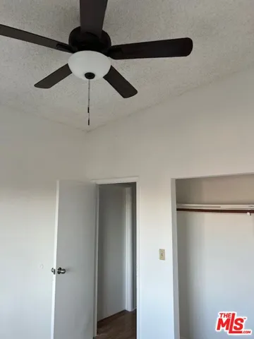 a bathroom with a shower and a ceiling fan