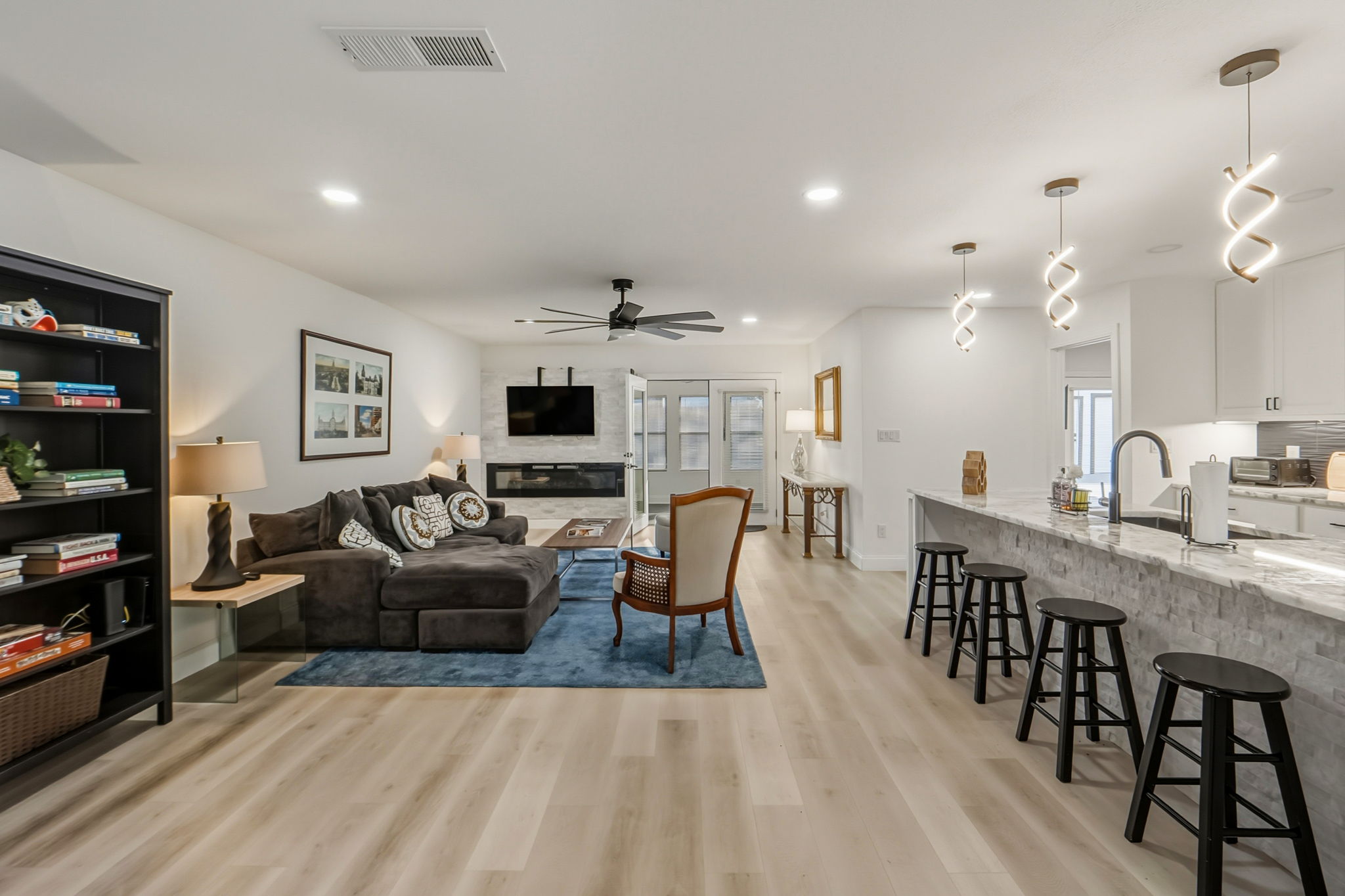 2107 Lewood Circle Austin, TX 78745 - Photo 3 of 30 Living area featuring a ceiling fan, light wood-type flooring, recessed lighting, and a glass covered fireplace