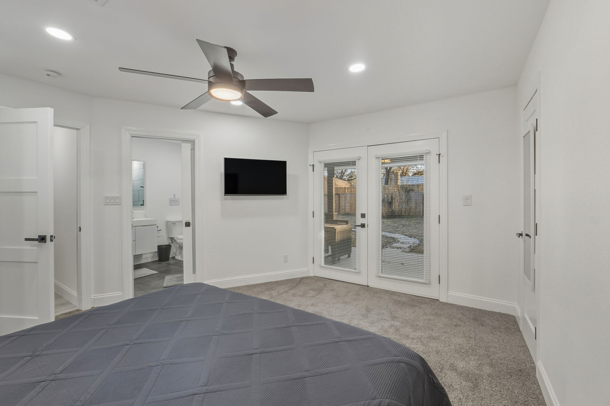 2107 Lewood Circle Austin, TX 78745 - Photo 9 of 30 Bedroom featuring light colored carpet, access to exterior, a ceiling fan, recessed lighting, and french doors