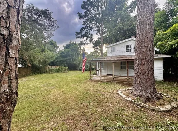 a view of house with a backyard