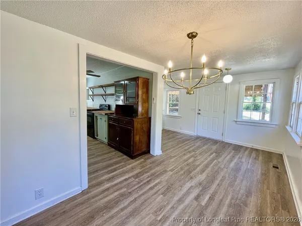 a view of a kitchen with wooden floor and cabinets