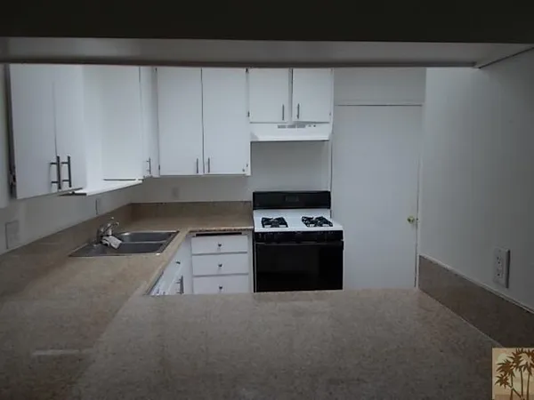 a kitchen with a stove and white cabinets