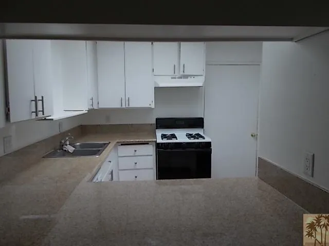 a kitchen with a stove and white cabinets