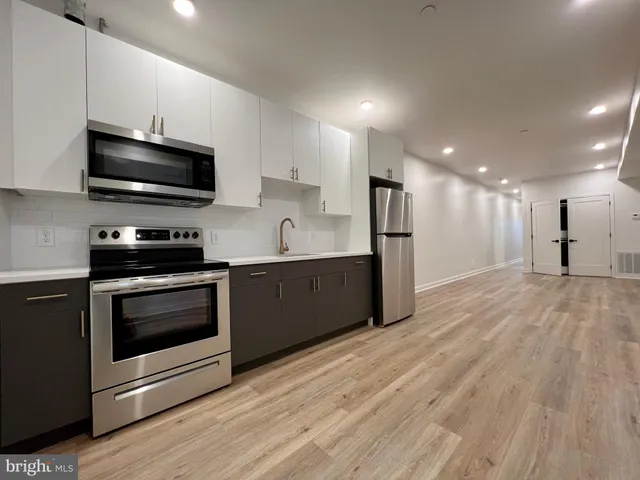 a kitchen with stainless steel appliances kitchen island granite countertop a stove a sink and a microwave