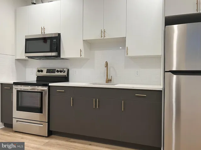 a kitchen with stainless steel appliances a sink a stove and a refrigerator