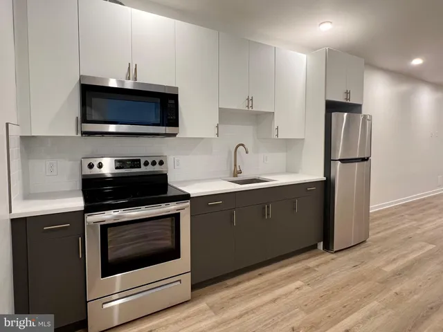 a kitchen with stainless steel appliances a stove microwave and sink