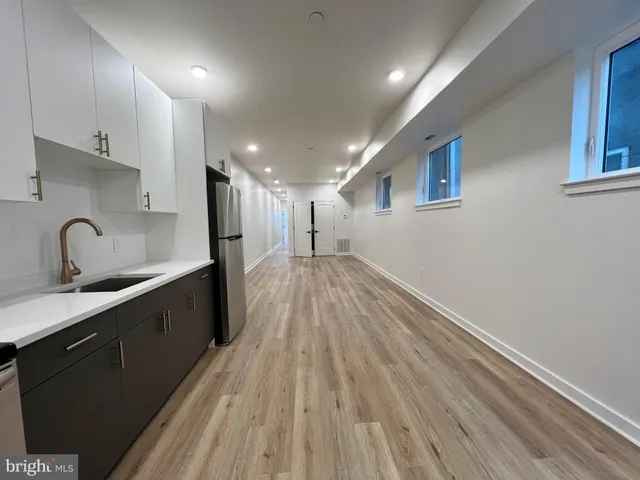 a view of a kitchen with a sink and wooden floor