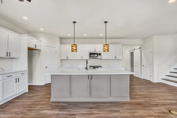 a large kitchen with kitchen island a sink stainless steel appliances and cabinets
