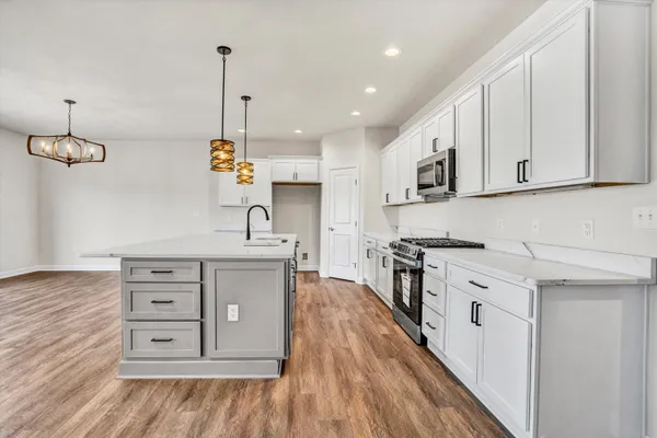 a kitchen with stainless steel appliances granite countertop a stove a sink and a refrigerator