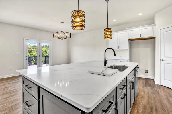 a kitchen with kitchen island stainless steel appliances and wooden floor