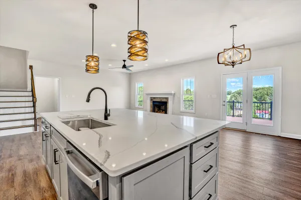 a kitchen with a sink a counter space and wooden floor