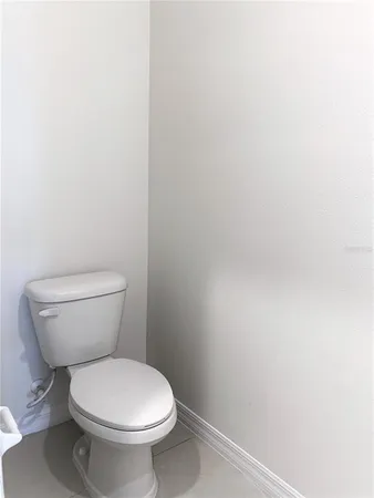 a white toilet sitting next to a white wall