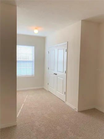 an empty room with windows and closet