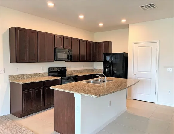 a kitchen with stainless steel appliances granite countertop wooden cabinets a stove and a sink