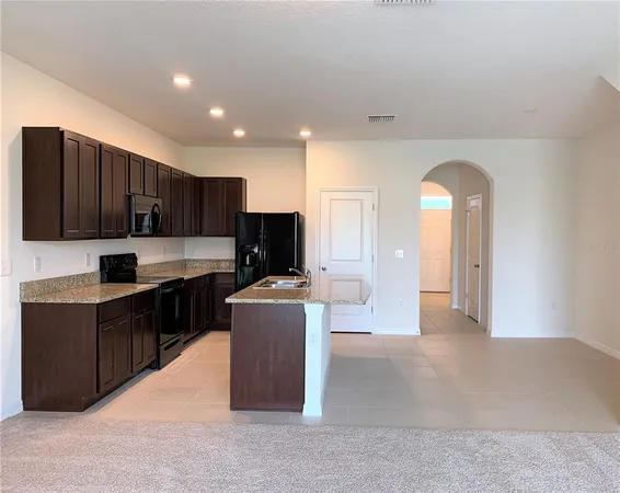 a kitchen with stainless steel appliances granite countertop a stove top oven a sink dishwasher a refrigerator and a oven